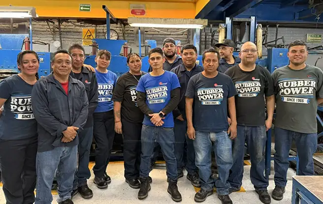 Complete team of Everest Group workers posing in corporate uniform in front of the plant